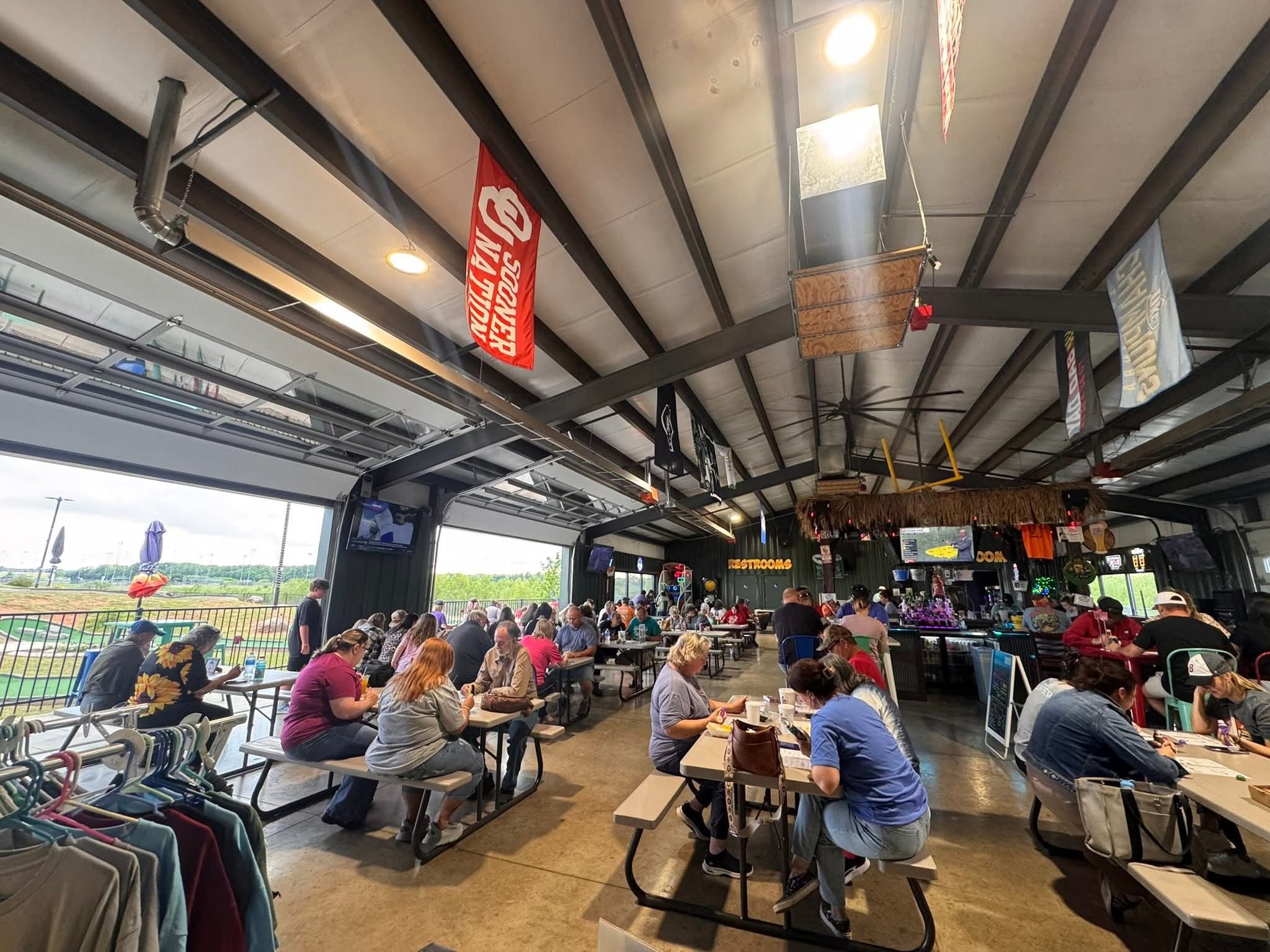 Full house at Jungle Ice Fun Zone with open garage doors and view of the golf course