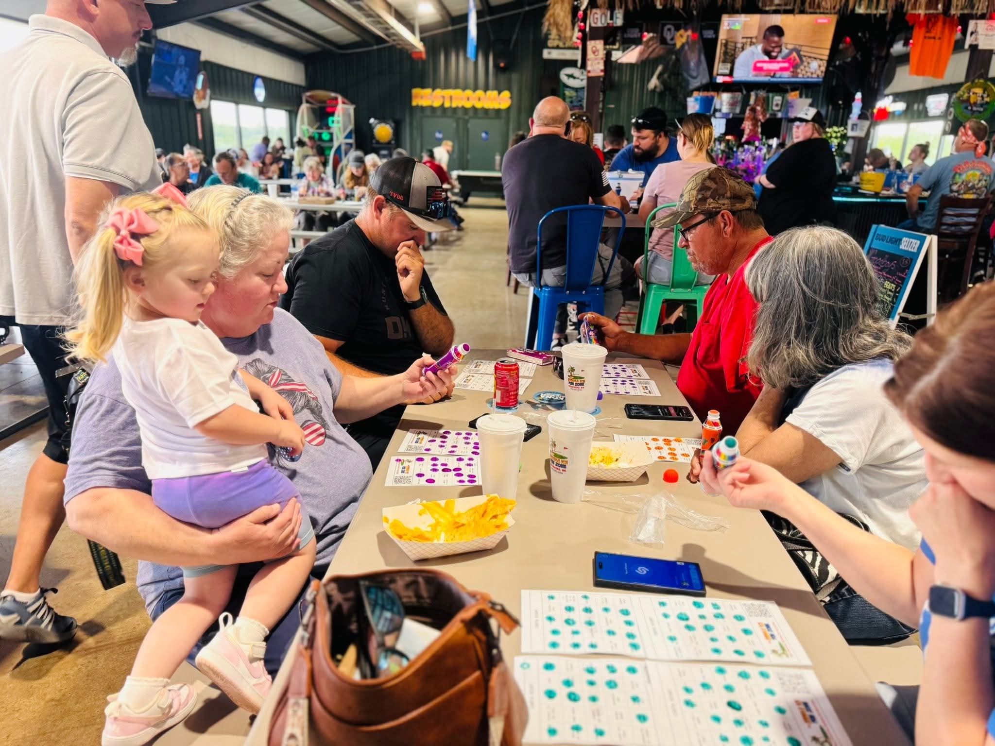 Wide view of a packed Singo night at Jungle Ice Fun Zone with open garage doors
