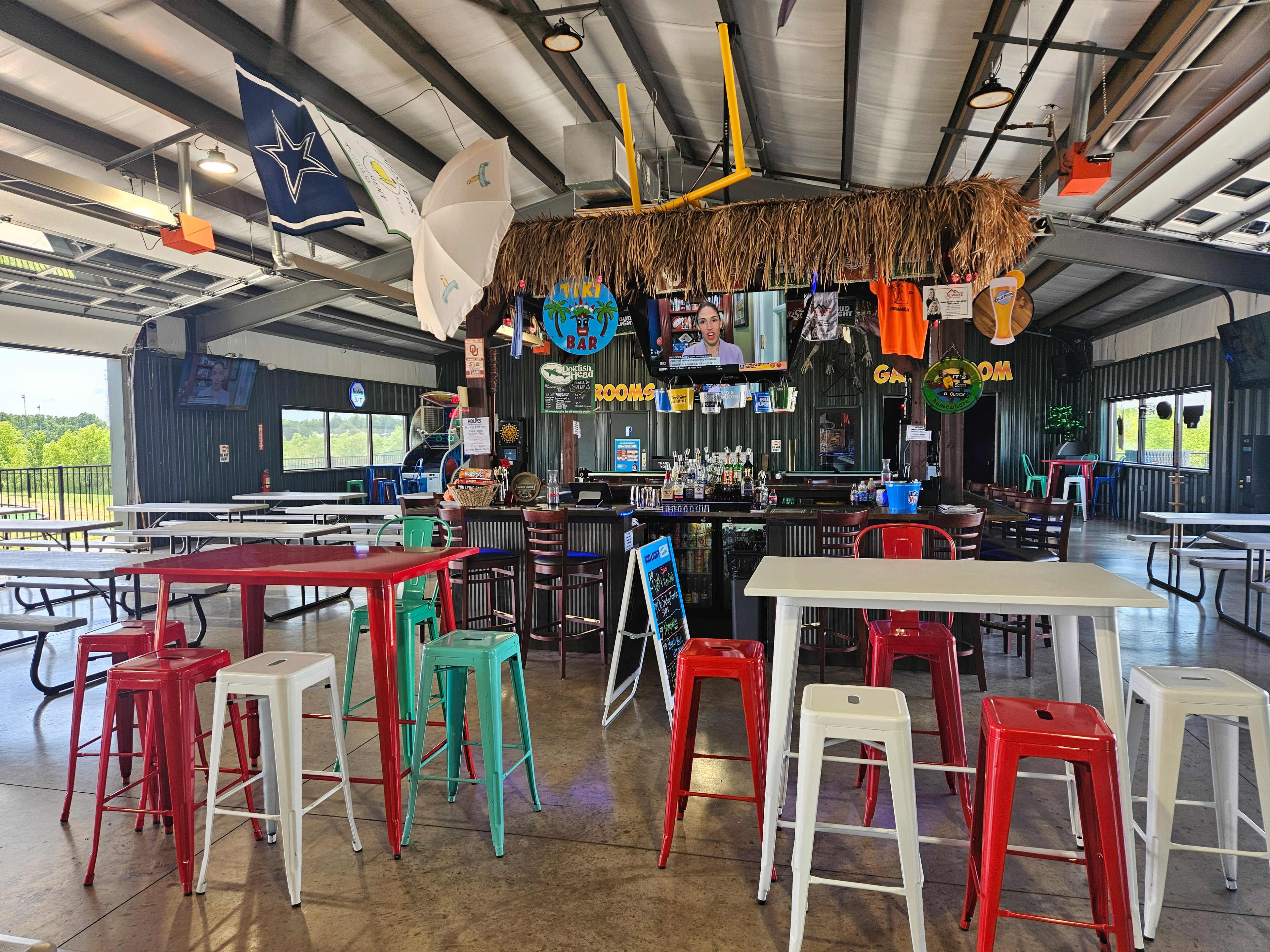 Tiki Bar daytime view with colorful stools and open garage doors at Jungle Ice Fun Zone